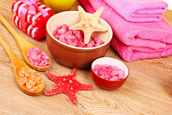 Bath aromatic salt, rose and sea stars on wooden background — Stock Photo, Image