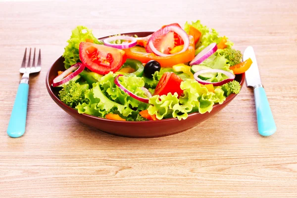 Salad of fresh vegetables in a plate and cutlery — Stock Photo, Image