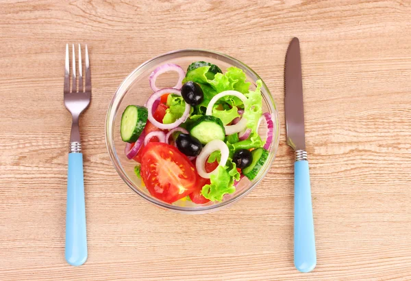 Салат из свежих овощей в тарелке и столовых приборах — стоковое фото