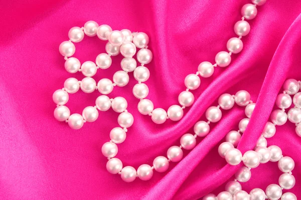 Smooth elegant red silk background with pearls — Stock Photo, Image