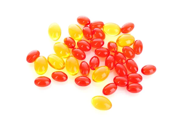 Cápsulas vermelhas e amarelas de vitaminas em um fundo branco — Fotografia de Stock