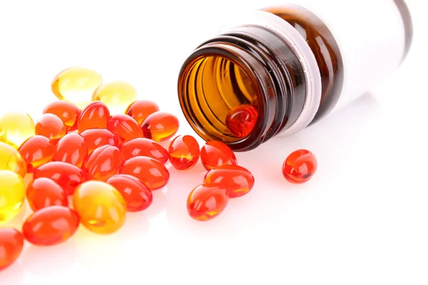 Red and yellow capsules of vitamins on a white background — Stock Photo, Image