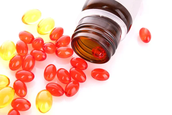 Red capsules of vitamins on a white background — Stock Photo, Image