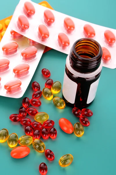 Červené kapsle vitamínů na modrém pozadí — Stock fotografie
