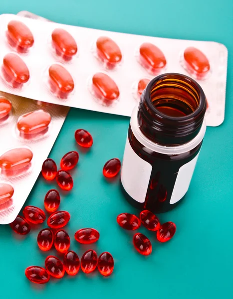 Vitamin mavi bir arka plan üzerinde kırmızı kapsül — Stok fotoğraf