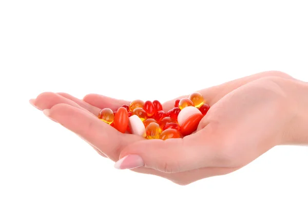 Red and yellow capsules of vitamins on the hand on a white back — Stock Photo, Image