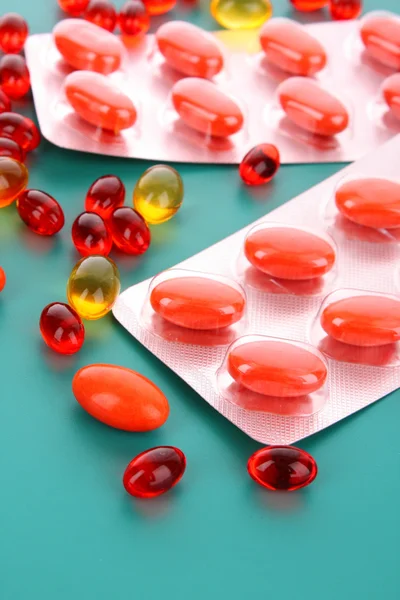Red capsules of vitamins on a blue background — Zdjęcie stockowe