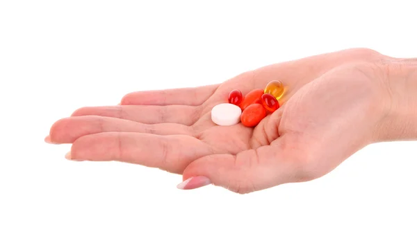 Красные и желтые капсулы витаминов на руке на белой спине — стоковое фото