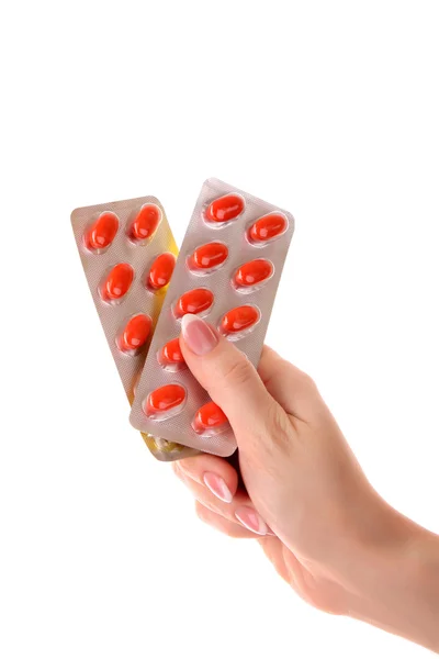 Red capsules of vitamins in the hand on a white background — Stock Photo, Image