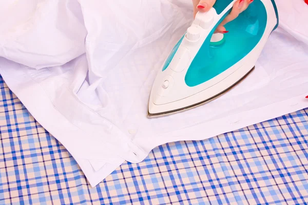 Woman hand ironing a shirt — Stock Photo, Image