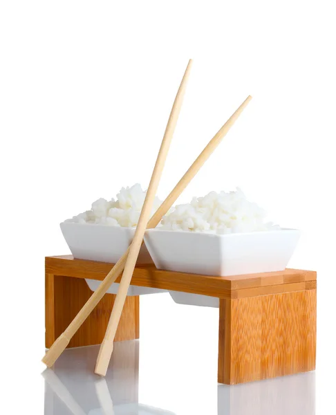 Two bowls on wooden stand of cooked rice and chopsticks — Stock Photo, Image
