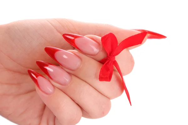 Naglar med rött nagellack och en rosett — Stockfoto