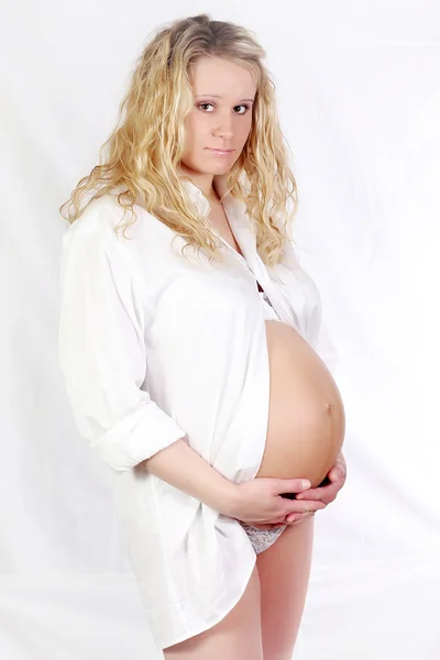 Беременная женщина держит живот руками — стоковое фото