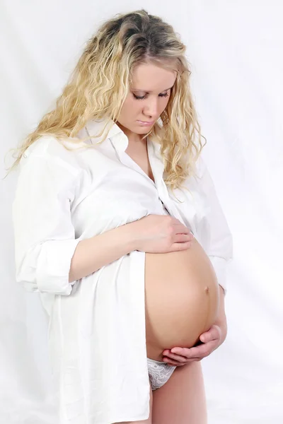 怀孕的女人按住她的肚子里用的手 — 图库照片