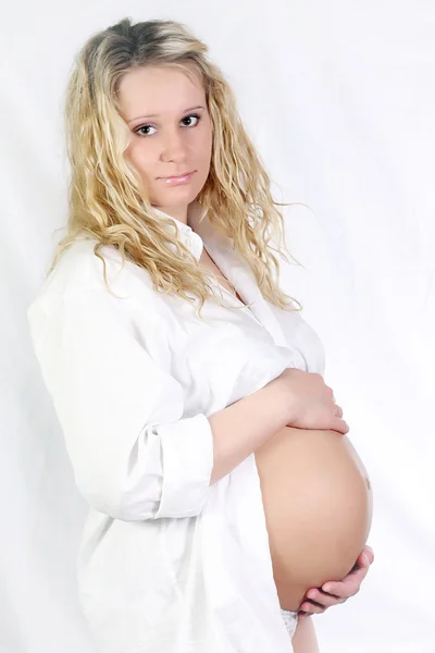 Těhotná žena drží její břicho rukama — Stock fotografie