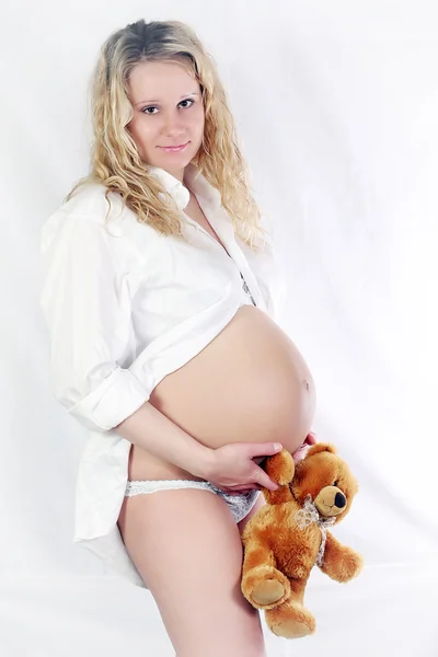 Mulher grávida com brinquedo de criança — Fotografia de Stock
