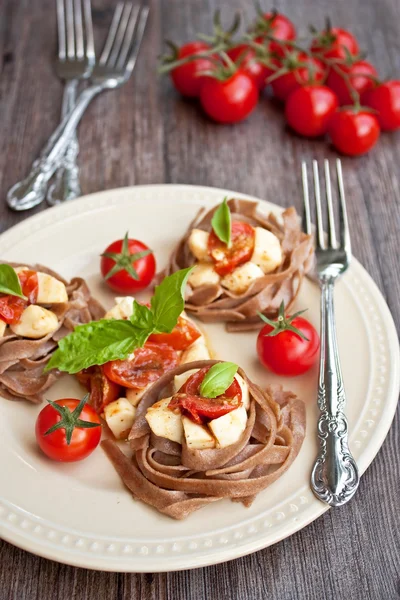 Pasta con tomates cherry y mozzarella Imágenes de stock libres de derechos