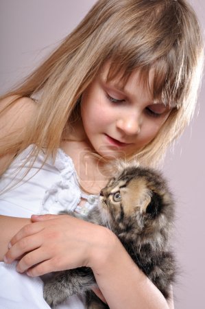 Enfant câlinant un chaton 