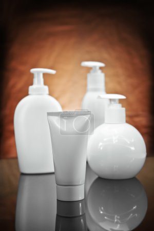 trois pulvérisations cosmétiques blanches et tube 