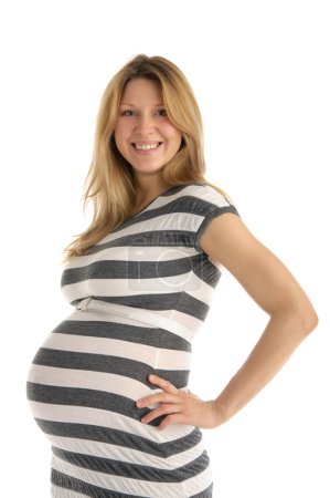 Heureuse femme enceinte en robe rayée 