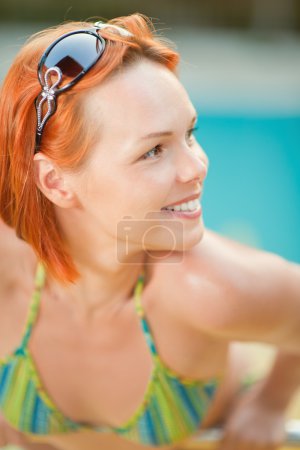 Femme souriante en bikini dans la piscine 