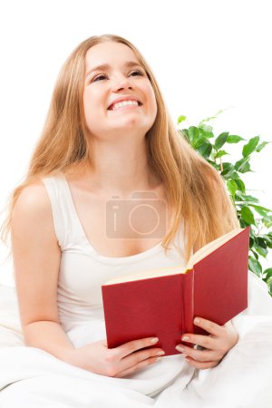 Femme lire livre assis dans le lit 