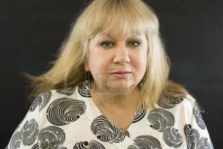 Femme d'âge moyen posant sur un fond noir 