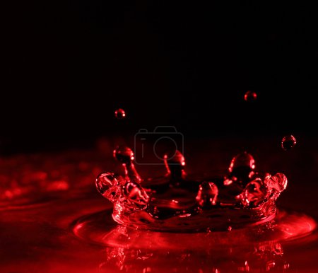 Eau éclaboussure de couleur rouge avec des gouttes 